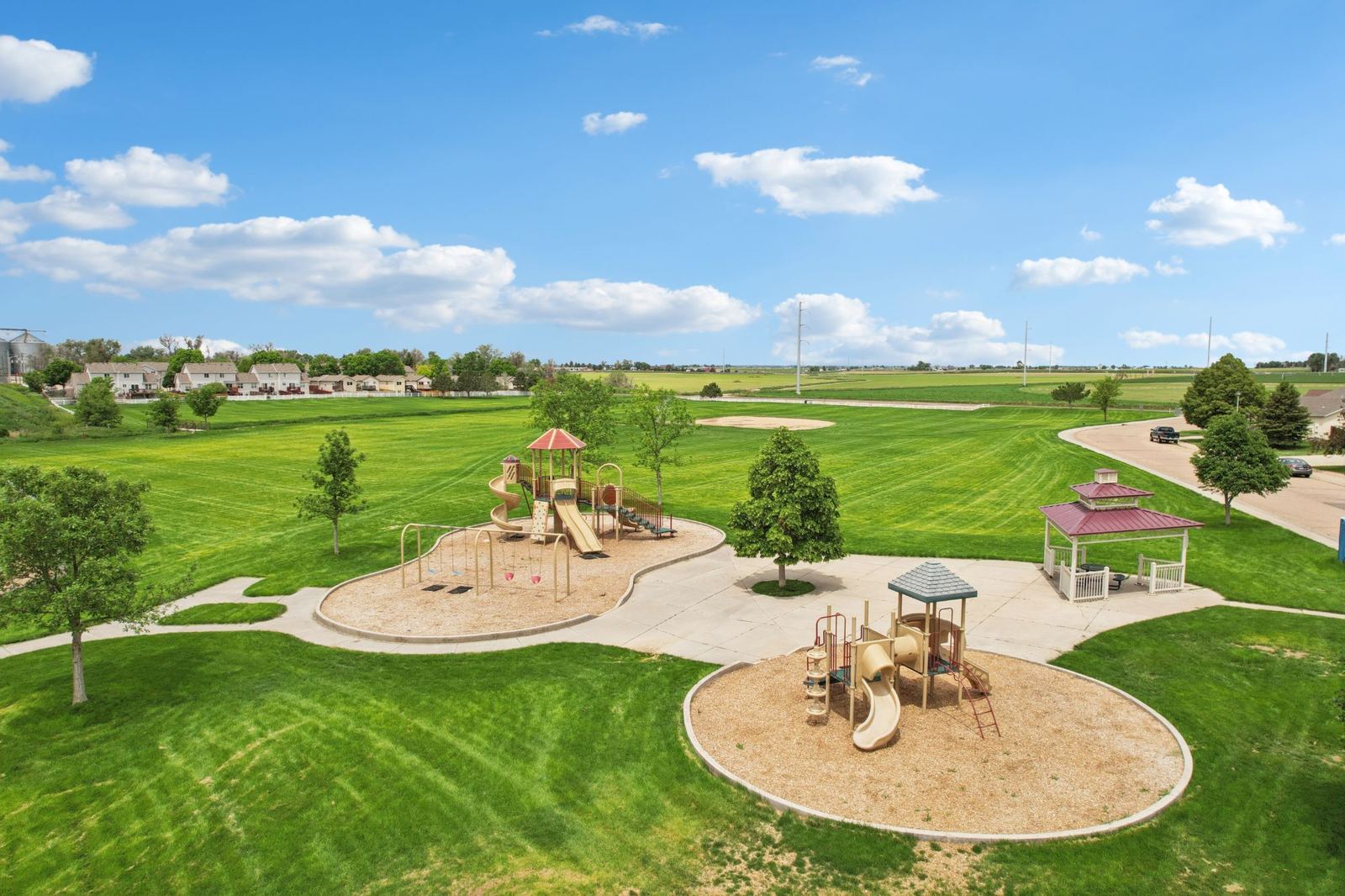 Twin playgrounds and a picnic gazebo at a neighborhood park in Eaton